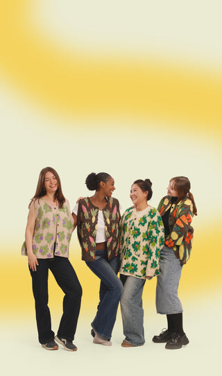 Four women wearing patterned cardigans and vests against a yellow and white gradient background.