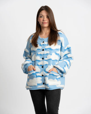 Woman wearing a blue cardigan with cloud pattern on a white background